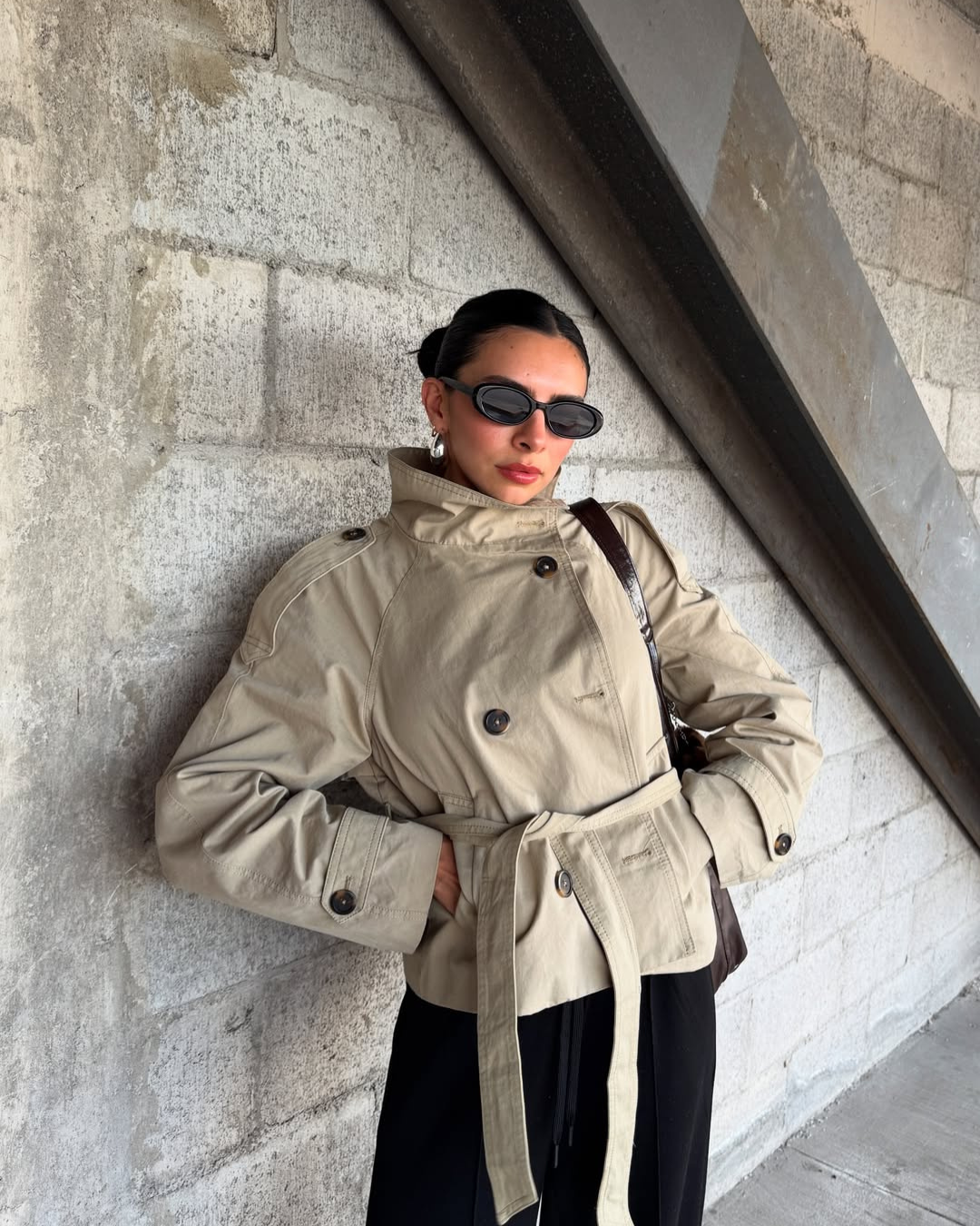 Close-up of beige short belted trench coat on model