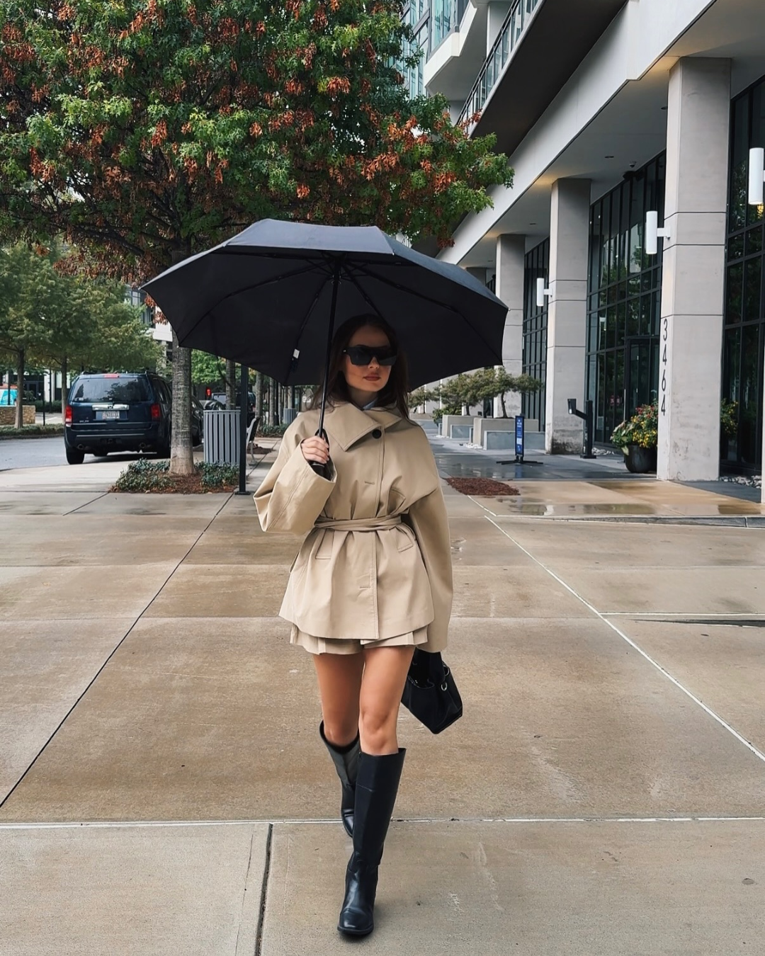 Beige trench jacket and shorts set, model with umbrella on street