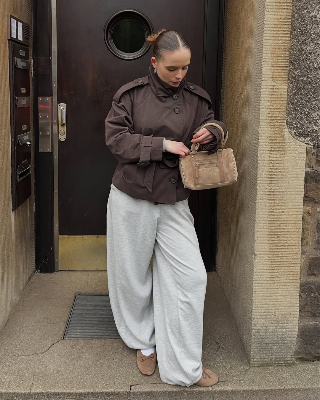 Brown short trench coat, model looking down, front view