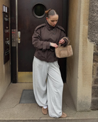 Brown short trench coat, model looking down, front view