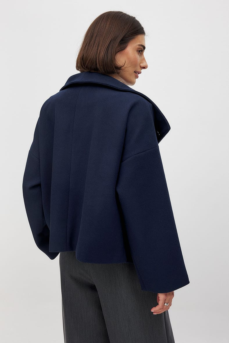 Navy double-breasted cropped coat, back view on model