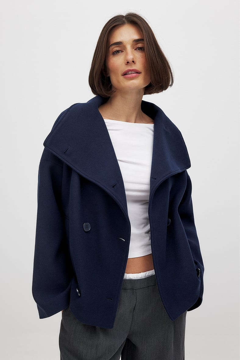 Navy double-breasted cropped coat, front view on model