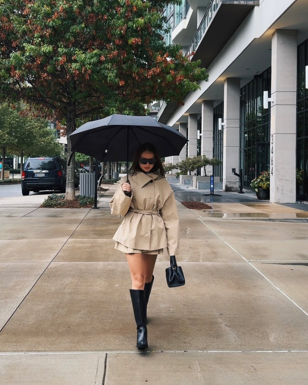 Beige trench jacket and shorts set, model walking with umbrella