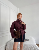 Wine red short belted trench coat, close-up front view on model