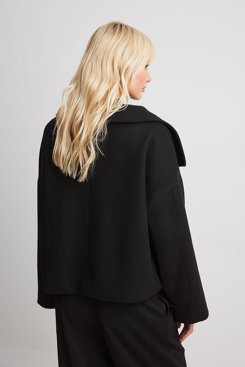 Black double-breasted cropped coat, back view on model