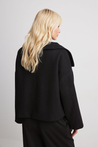 Black double-breasted cropped coat, back view on model