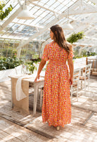 Orange floral print maxi dress, back view on model