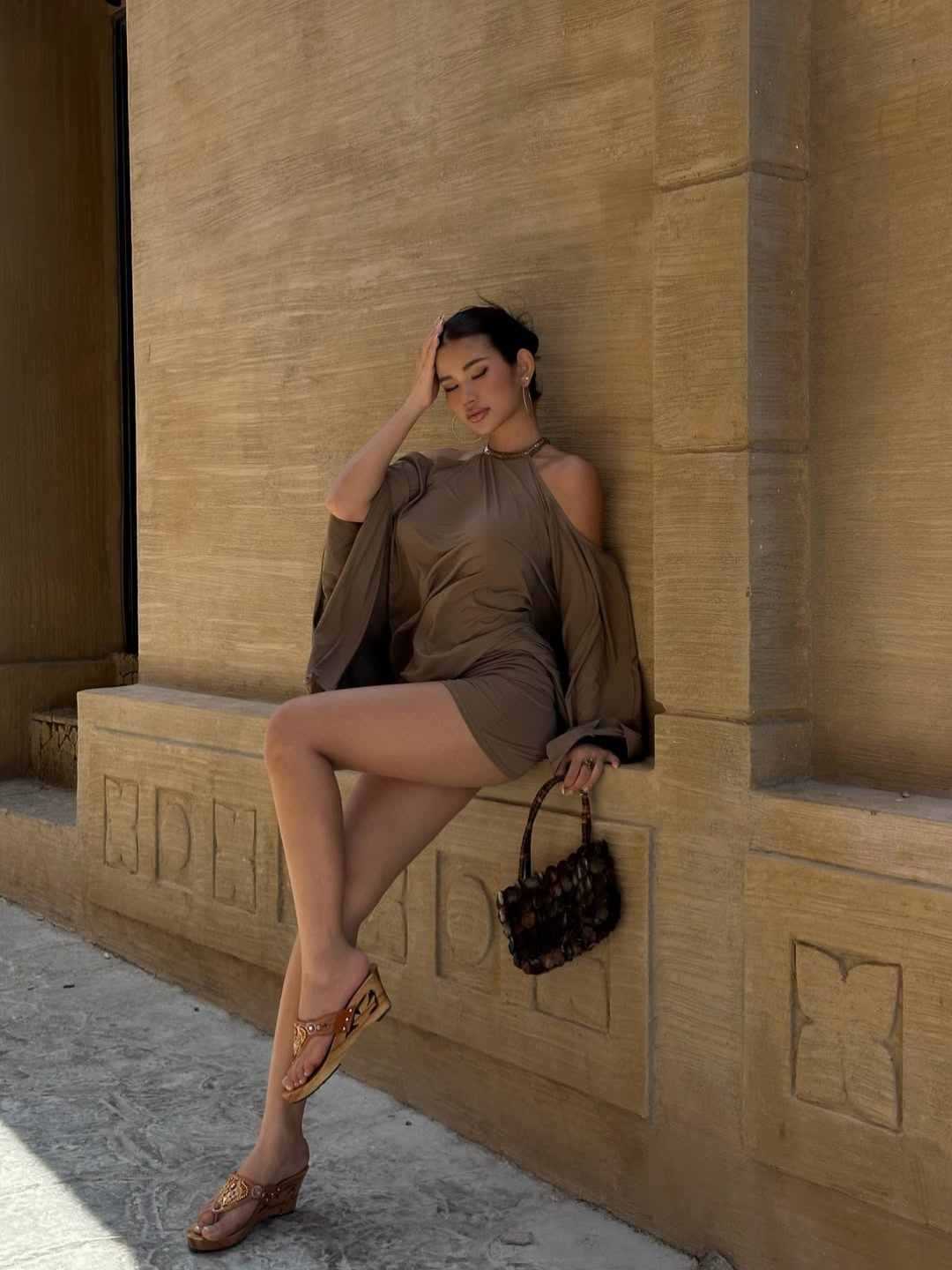Taupe halter mini dress, model seated, front view