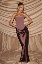Mocha strapless satin maxi dress, lifestyle shot against draped backdrop