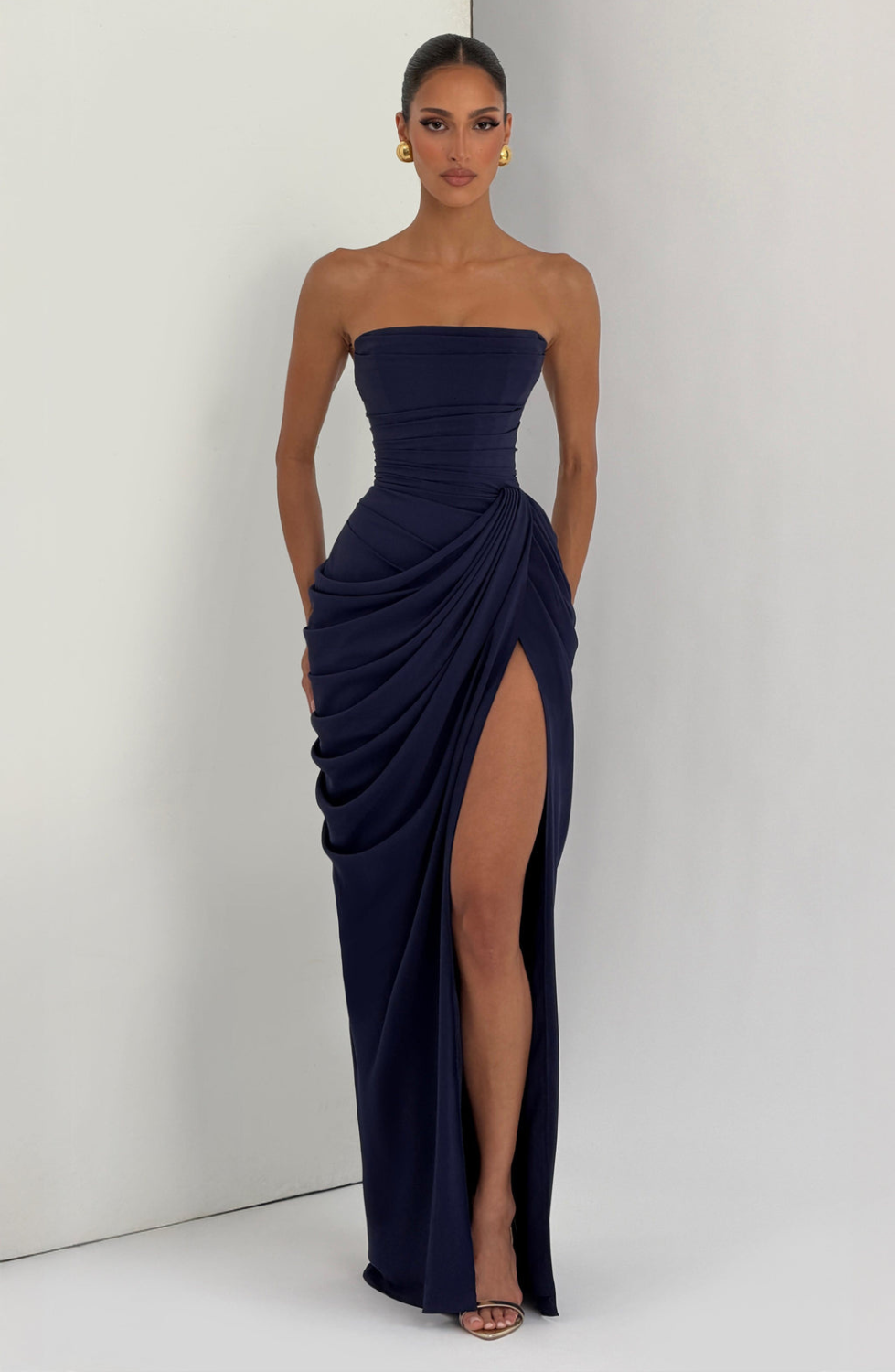 Navy strapless maxi dress with thigh split, model indoors