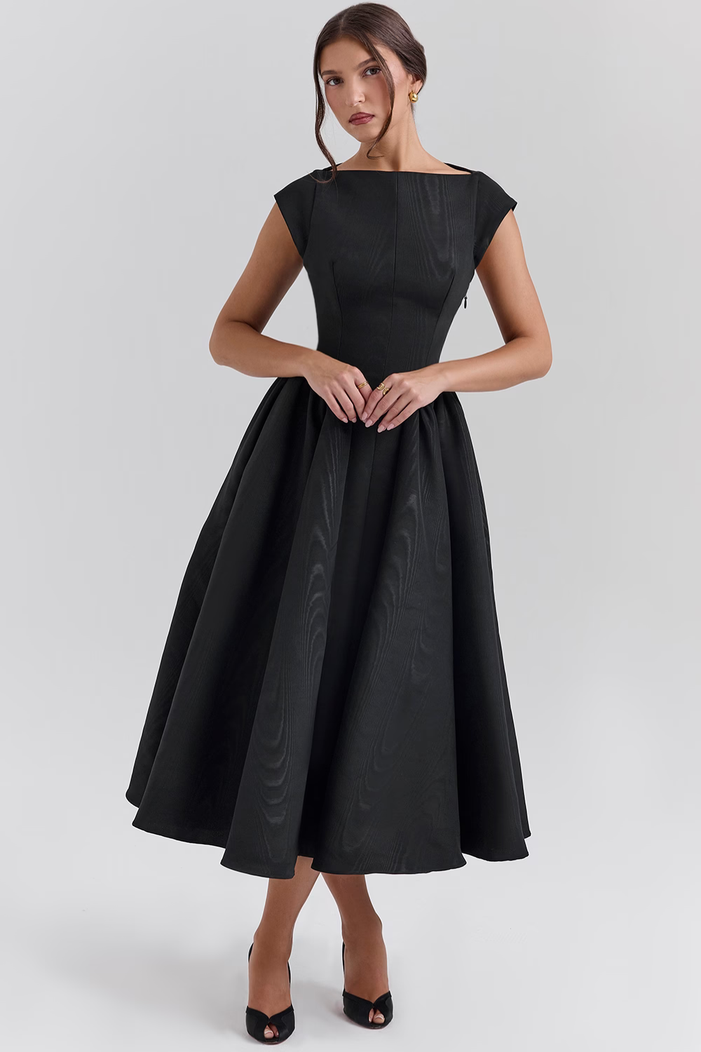 Black full-skirt midi dress, front view with hands clasped