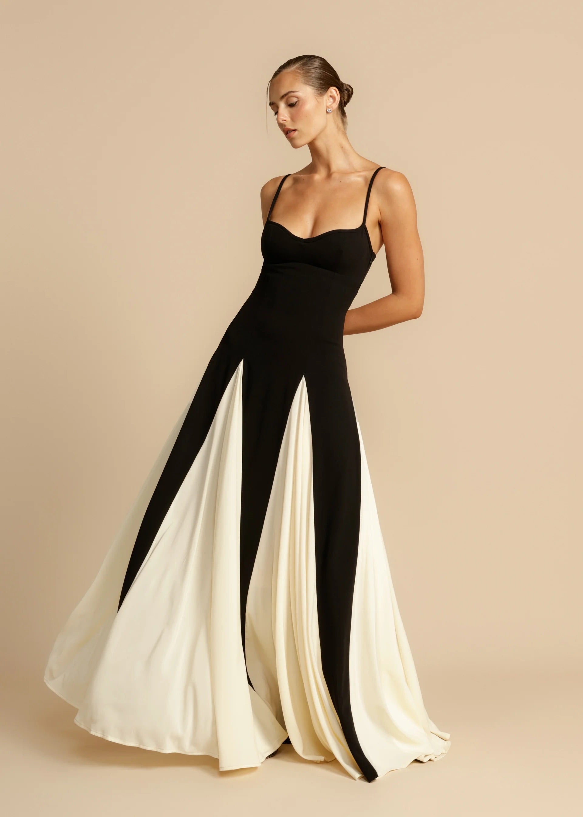 Black maxi dress with ivory godets, three-quarter view on model