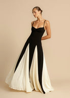 Black maxi dress with ivory godets, three-quarter view on model