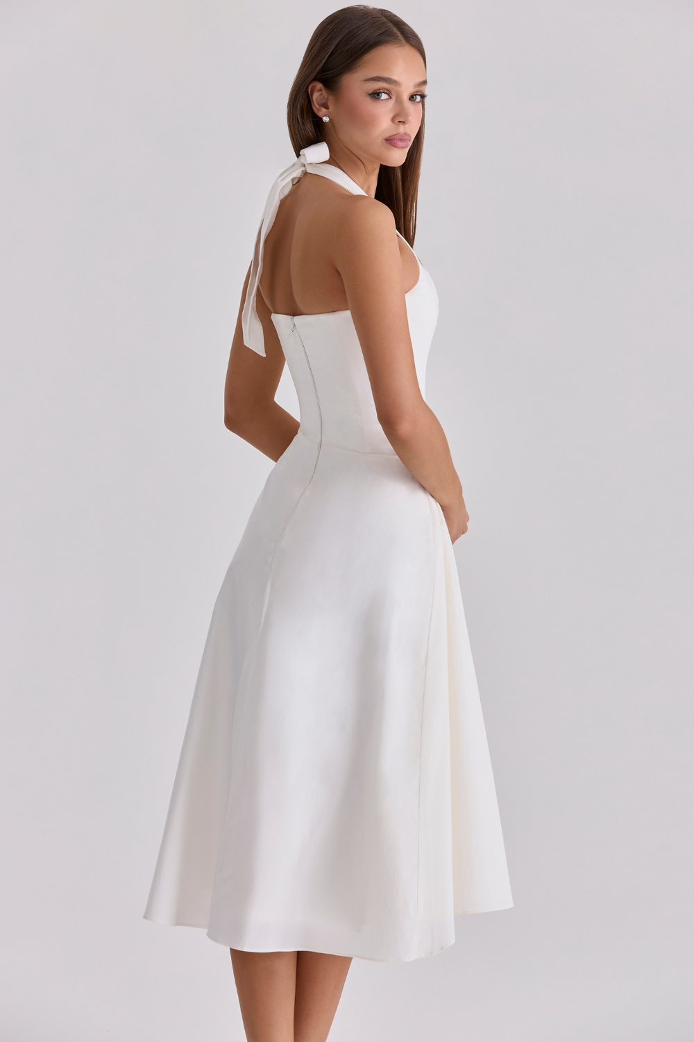 Ivory halter-neck midi dress with fitted bodice, rear three-quarter view on model