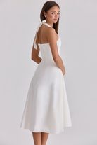 Ivory halter-neck midi dress with fitted bodice, rear three-quarter view on model
