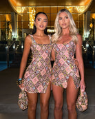Two models wearing sequinned diamond-pattern mini dresses outdoors