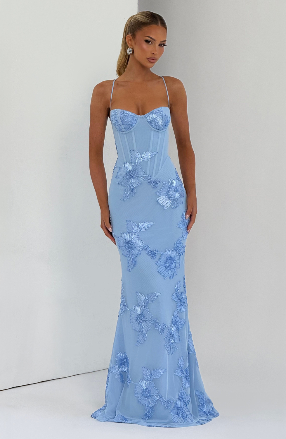 Baby blue fitted maxi dress with floral lace embroidery, model indoors