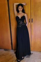 Black lace maxi dress, front view on model against wooden doors