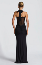 Black halter neck maxi dress with bow tie neck, back view on model