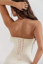 Close-up of ivory dress corset lacing and beaded fringe on back