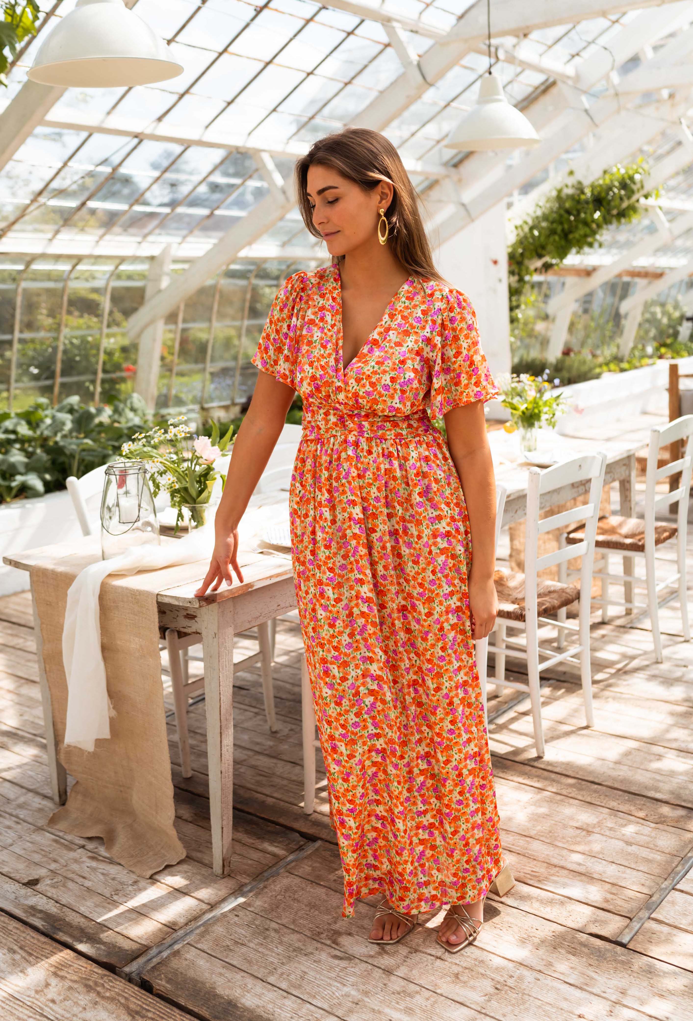 Orange floral print maxi dress, front view on model indoors