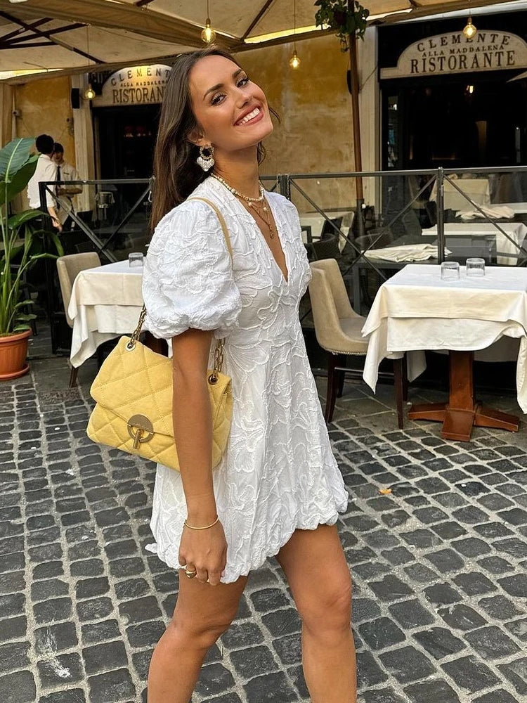 White embroidered mini dress, side angle on model