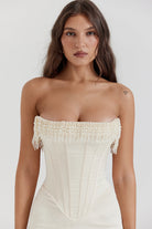 Close-up of ivory corset dress bodice with pearl beaded trim