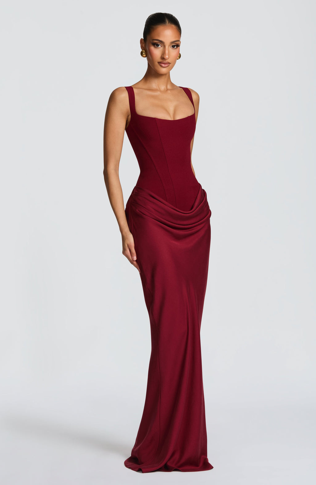 Burgundy corset-style maxi dress on model, arms down pose