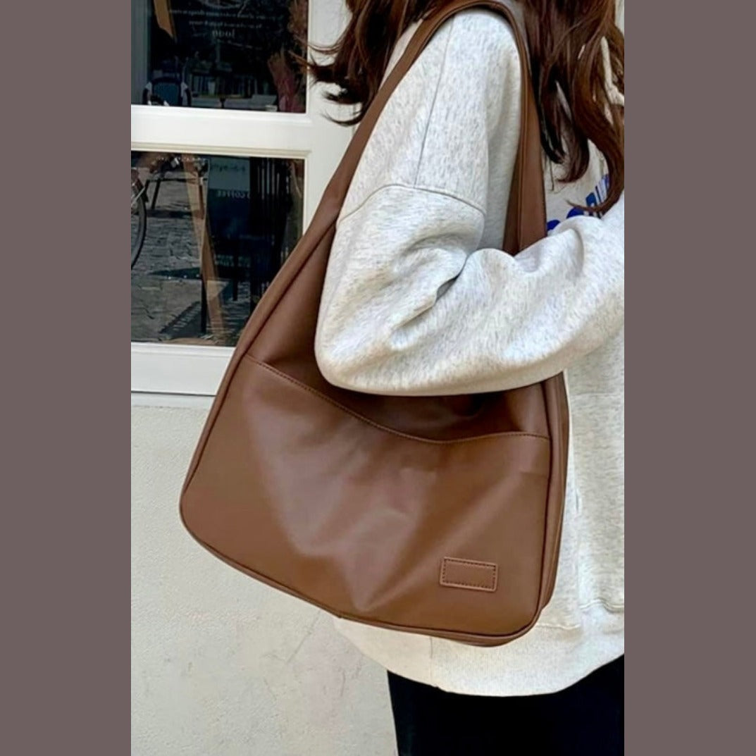Mocha brown leather slouchy shoulder bag worn on model, close-up