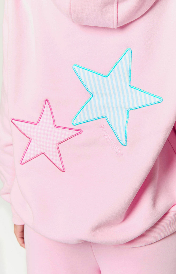 Close-up of pink hoodie back, gingham and striped star patches