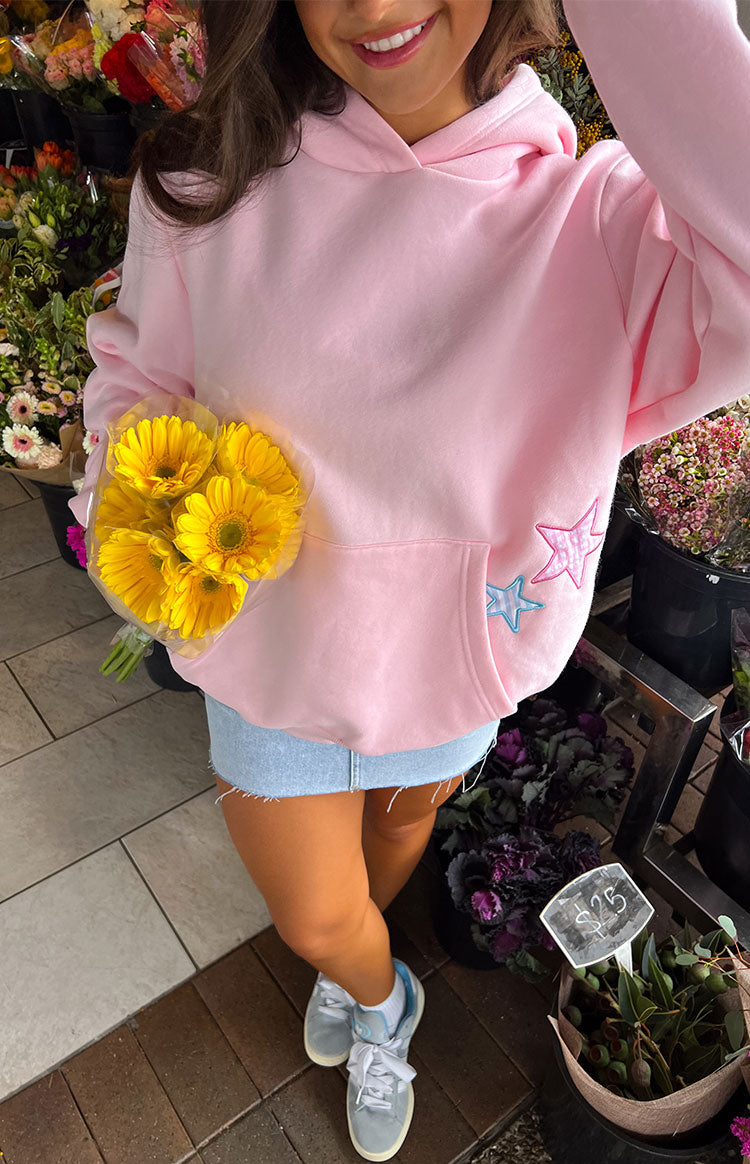 Pink hoodie with star patches, overhead view showing kangaroo pocket