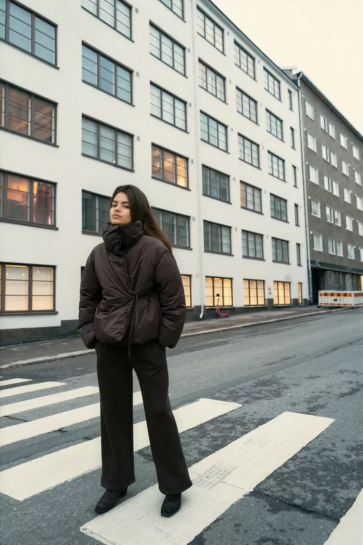 Brown wrap puffer jacket on model, tied waist, street view