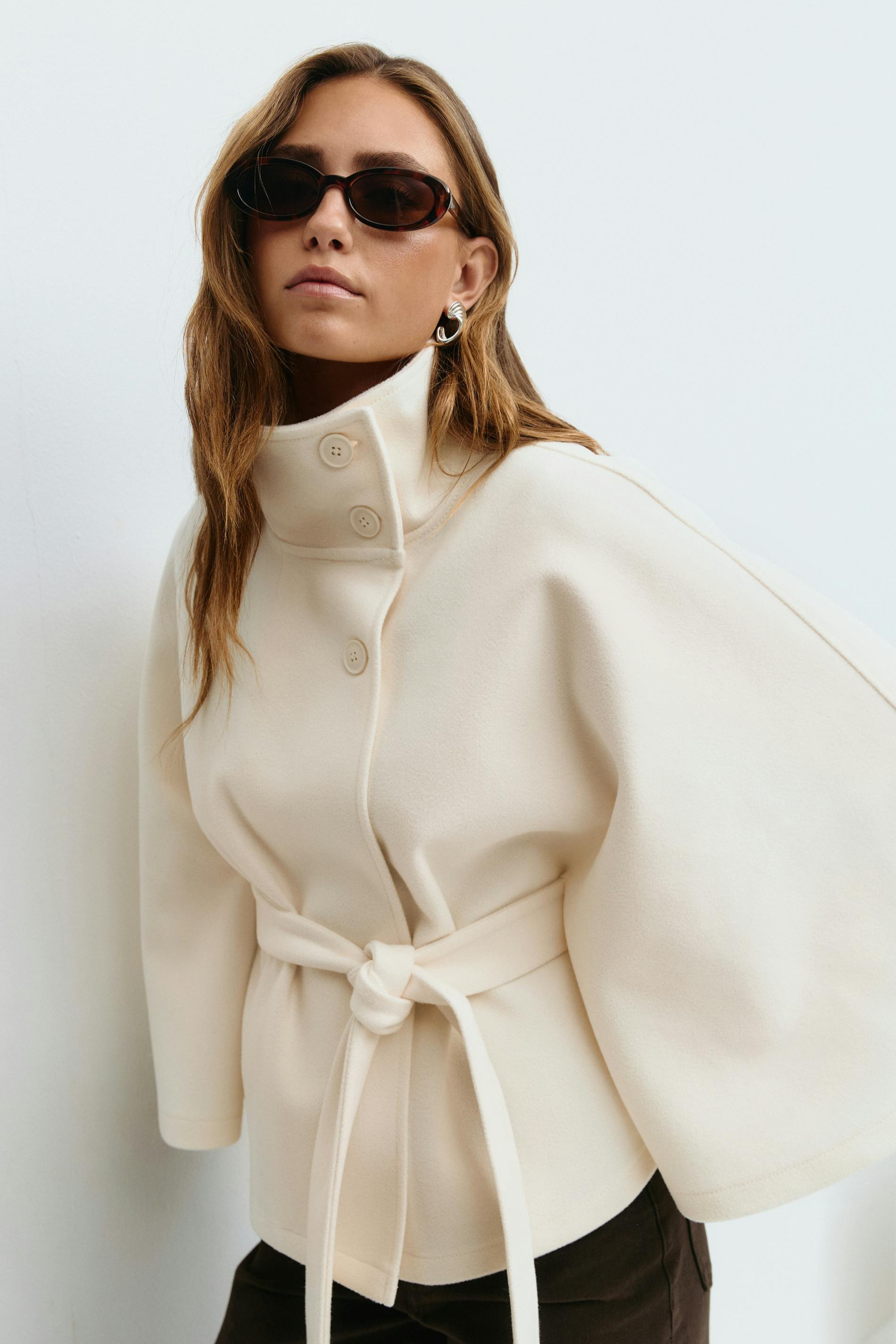White belted cape jacket, close-up front view on model