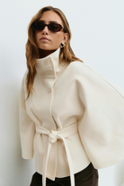 White belted cape jacket, close-up front view on model