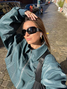 Deep green oversized contrast-stitch jacket, close-up selfie outdoors