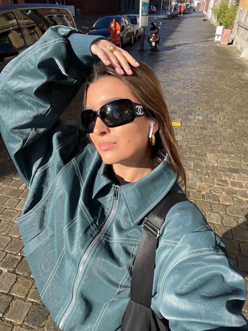 Deep green oversized contrast-stitch jacket, close-up selfie outdoors