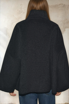 Dark grey cropped wool jacket on model, back view