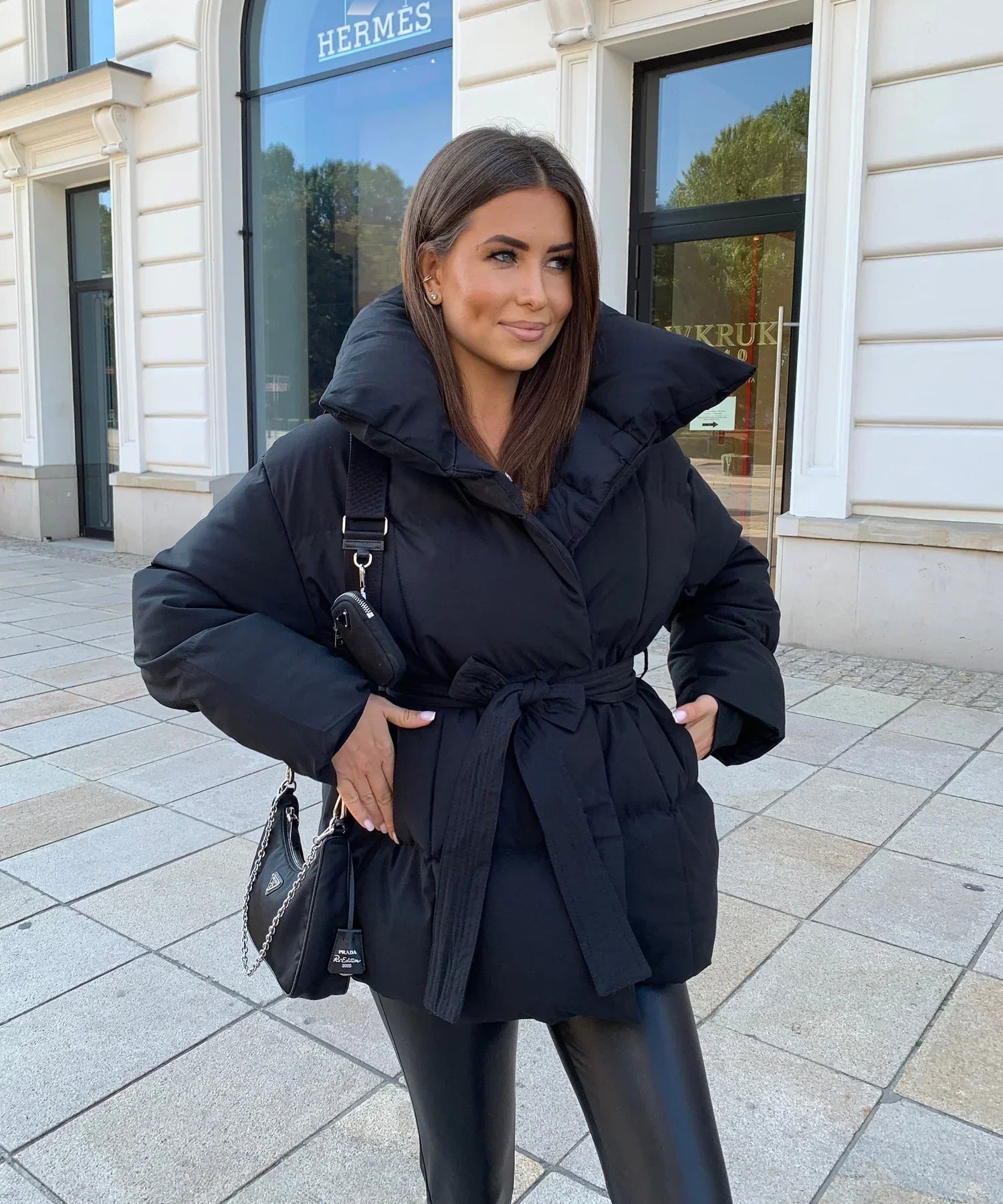 Black belted puffer jacket, front view on model, street style