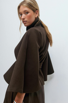 Brown belted cape jacket, side view on model