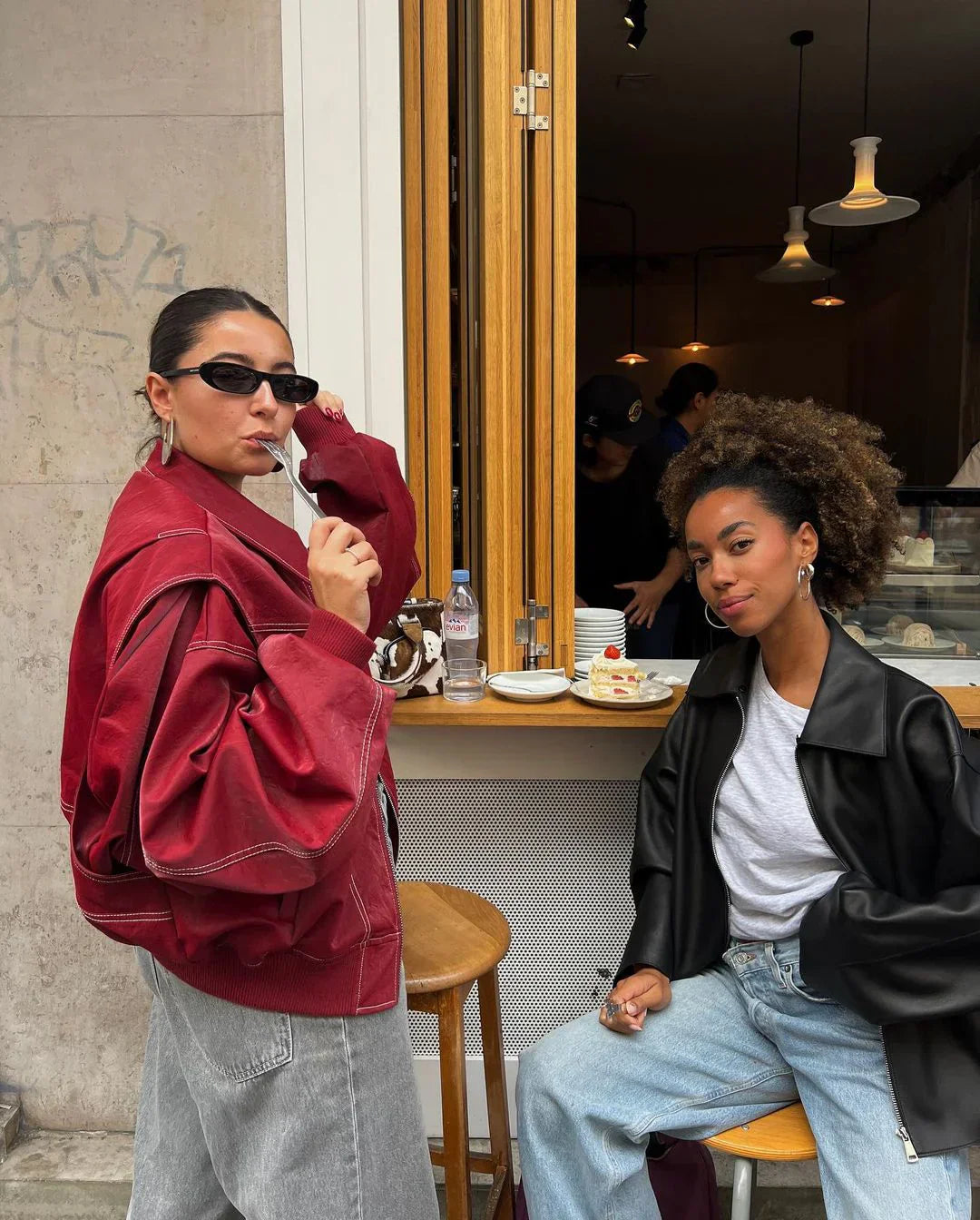 Red oversized contrast-stitch jacket, side view with friend at cafe