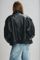 Black oversized leather jacket on model, back view