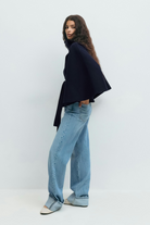 Midnight blue belted cape jacket, side view on model
