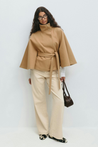 Beige belted cape jacket, full length front view on model