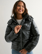 Close-up of black glossy hooded puffer jacket on model