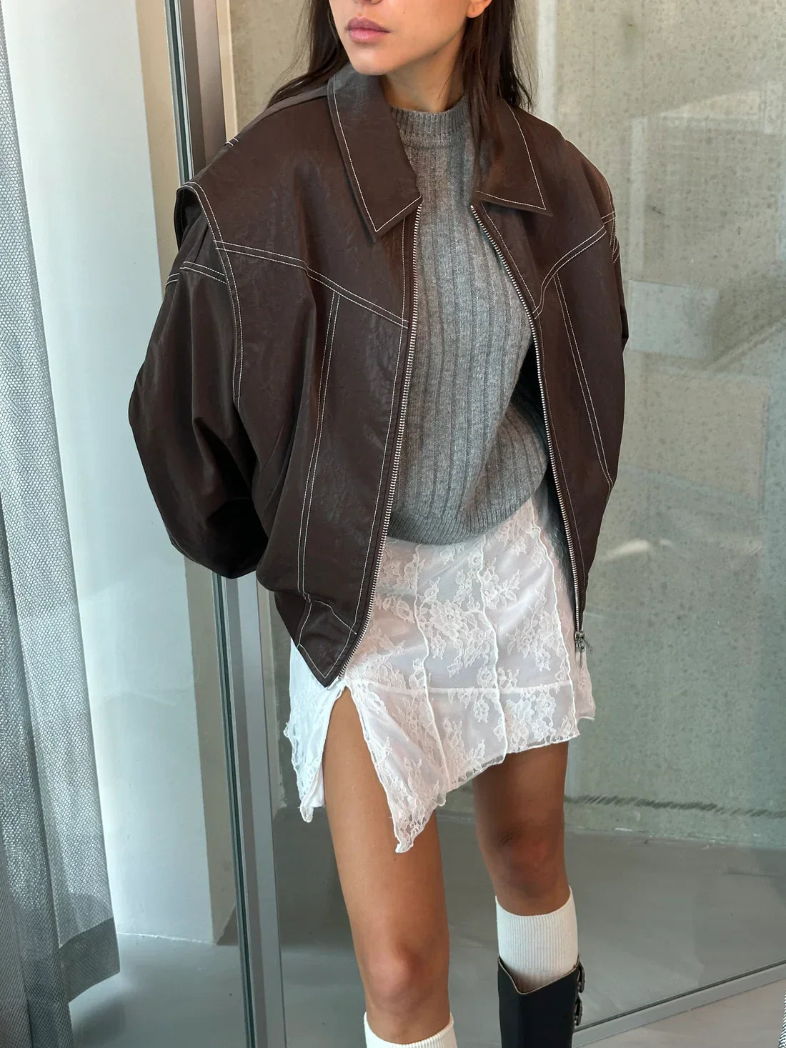 Brown oversized contrast-stitch jacket over lace skirt, close-up front view