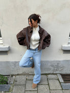 Brown oversized contrast-stitch jacket over jeans, front view
