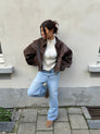 Brown oversized contrast-stitch jacket over jeans, front view