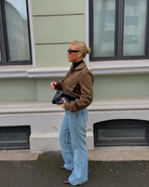 Brown suede bomber jacket, full length side view on model