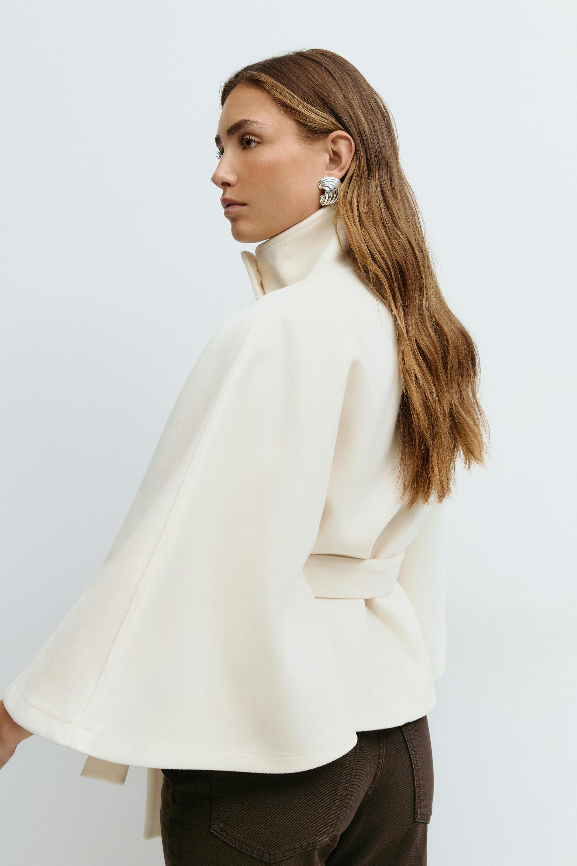 White belted cape jacket, back view close-up on model