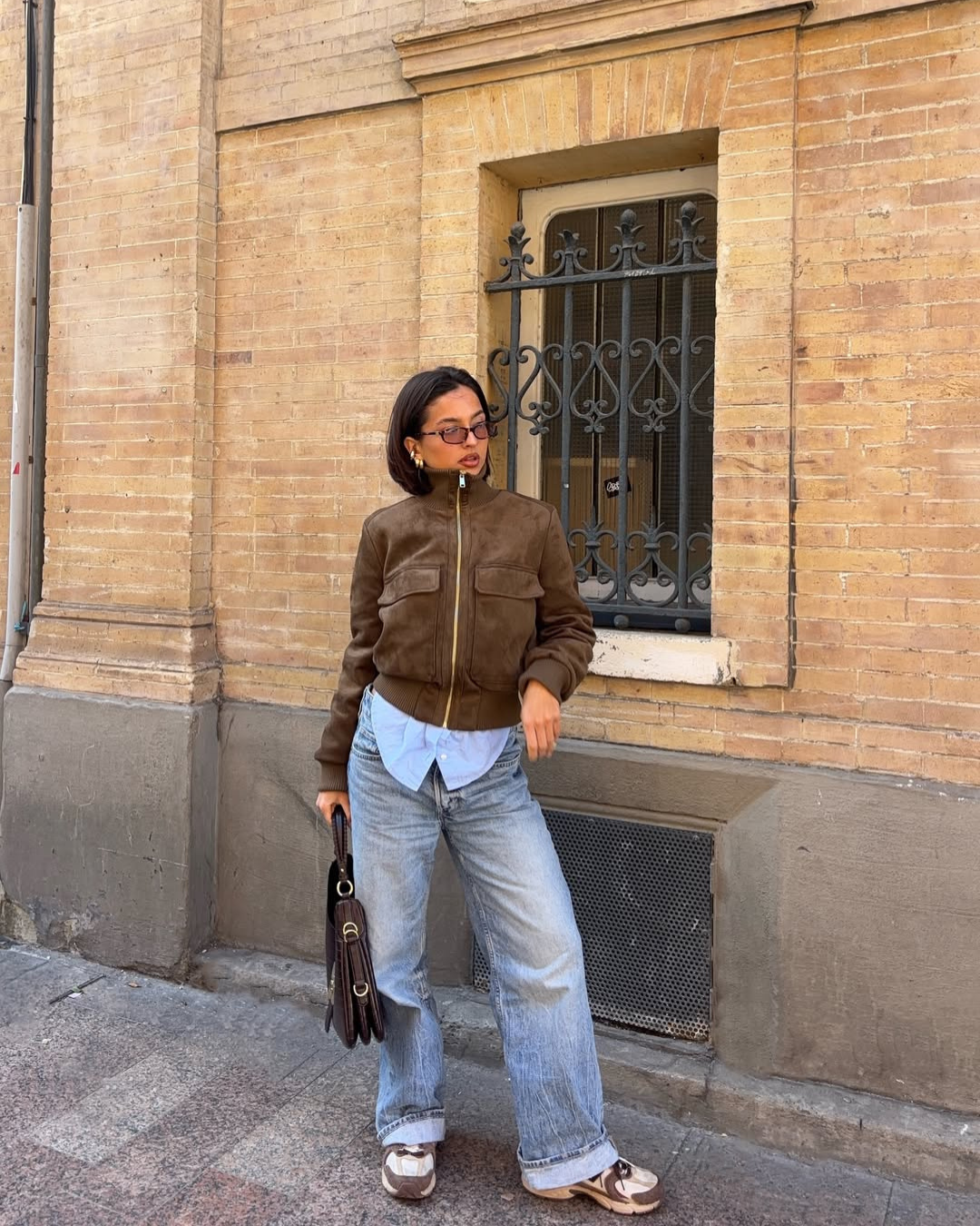 Brown suede bomber jacket, model glancing sideways, front view